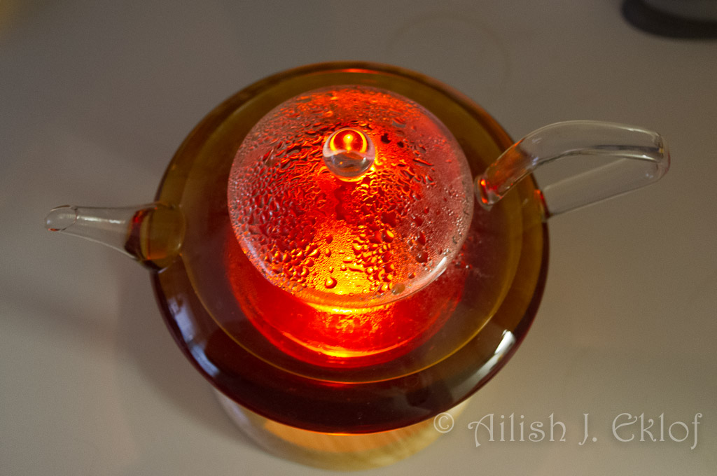 Tea, in a glass pot, lit by a tea light from below.